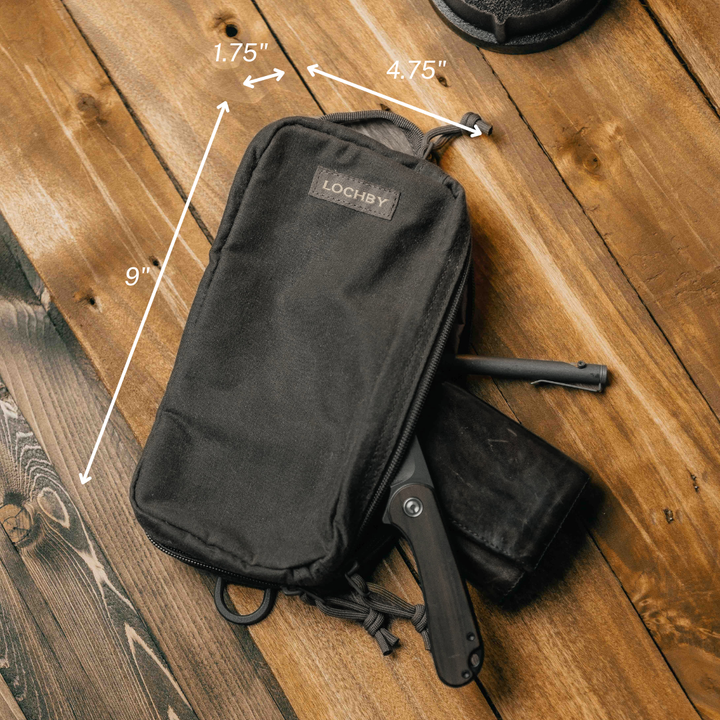Black pouch with measurements and a knife on a wooden surface, featuring the brand 'LOCHBY'.