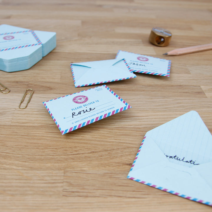 Stacks of envelopes with personalized text on a wooden surface