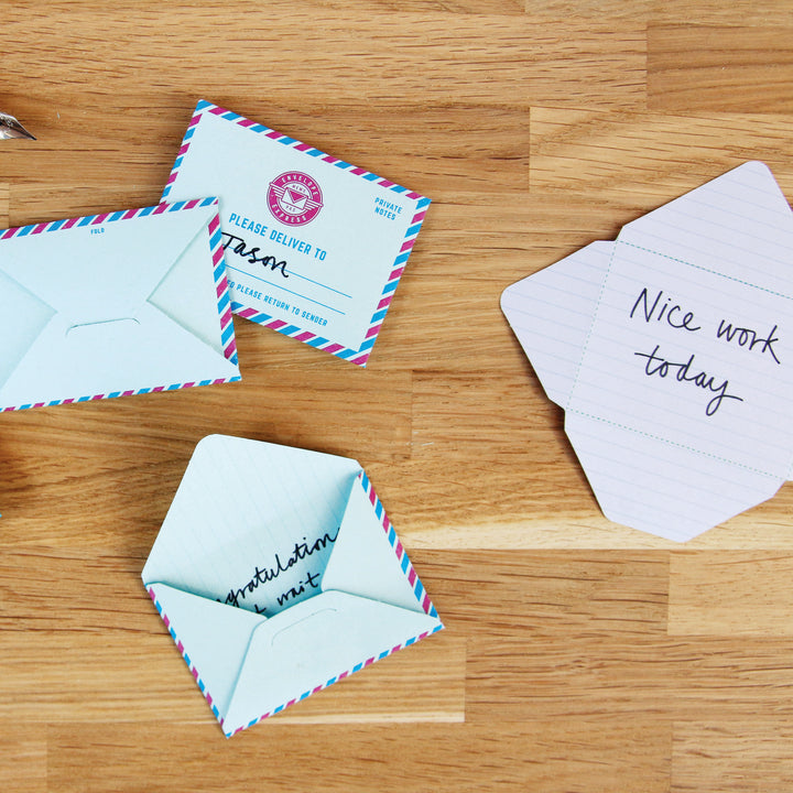 Small envelopes with printed text on a wooden surface