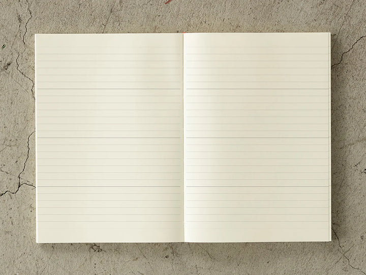Open notebook with lined pages on a textured concrete surface