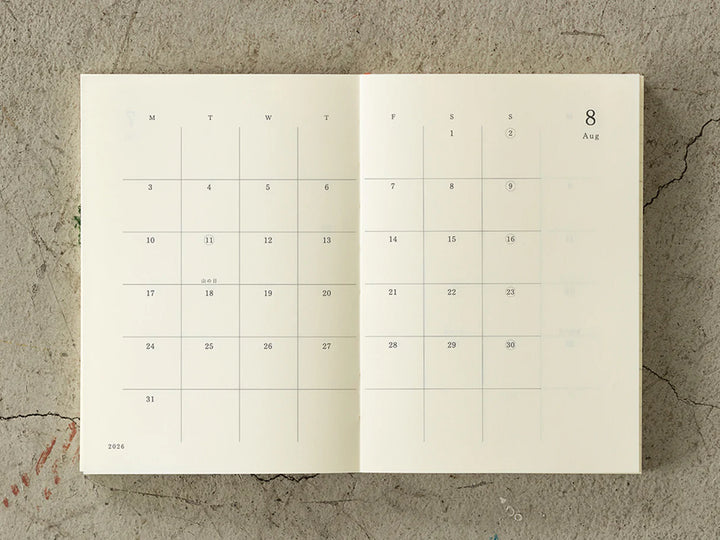 Calendar open to August 2026 on a textured surface