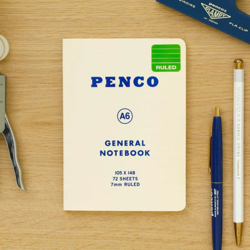 Penco notebook on a wooden surface with stationery items