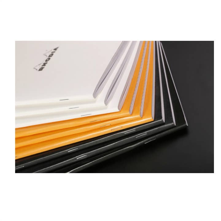 Set of notebooks in various colors on a black background