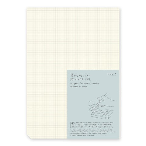 Notebook with grid pattern on beige cover and blue label with text