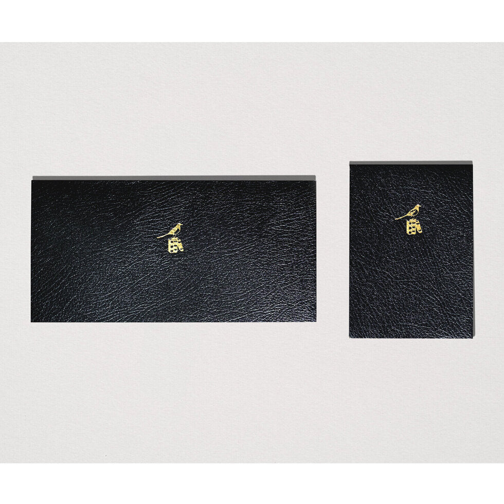Two black notebooks with gold embossing.