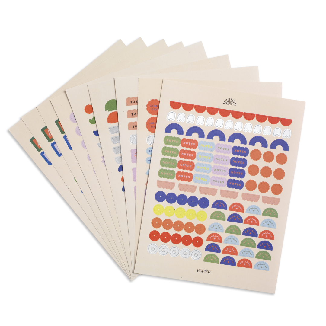 Set of colorful dot stickers on beige paper with a visible brand logo.