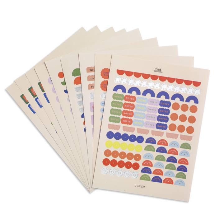 Set of colorful dot stickers on beige paper with a visible brand logo.