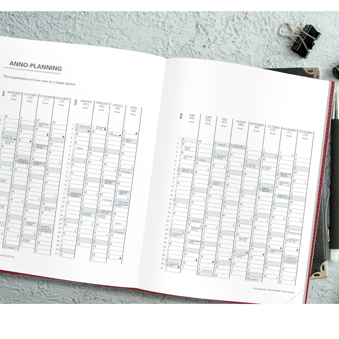 Open planner with monthly schedule on a gray surface