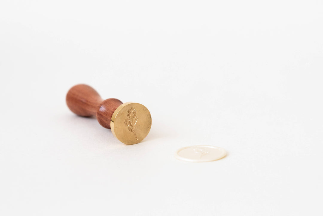 Gold daisy stamp with wooden handle on a white background