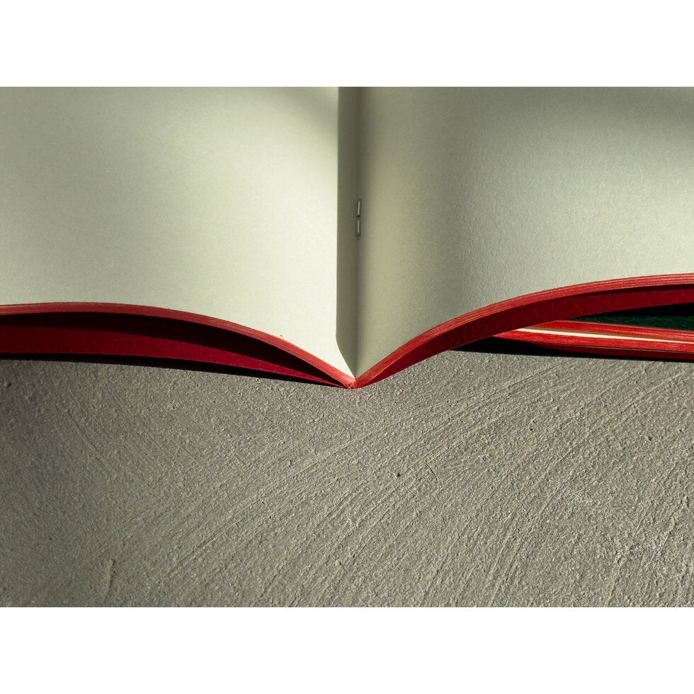 Open book with red edges on a textured surface