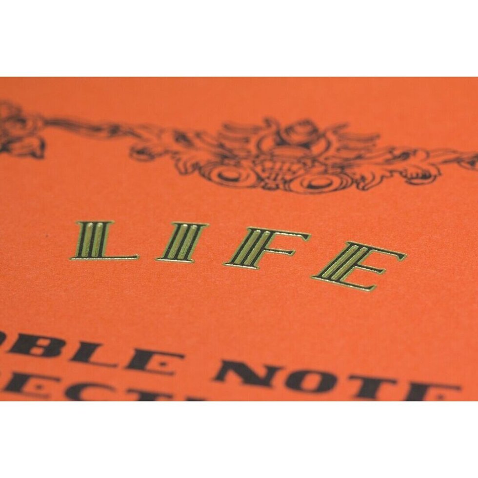 Notebook cover with decorative text and 'LIFE' on an orange background.