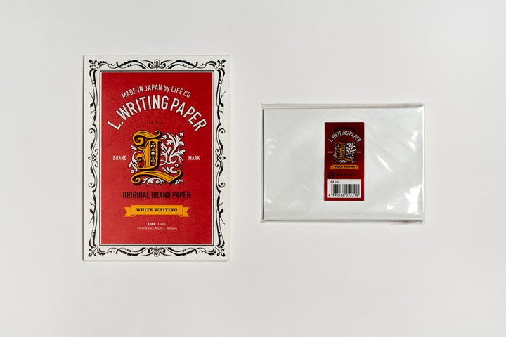 Writing paper set with red label and white envelope on a light gray background
