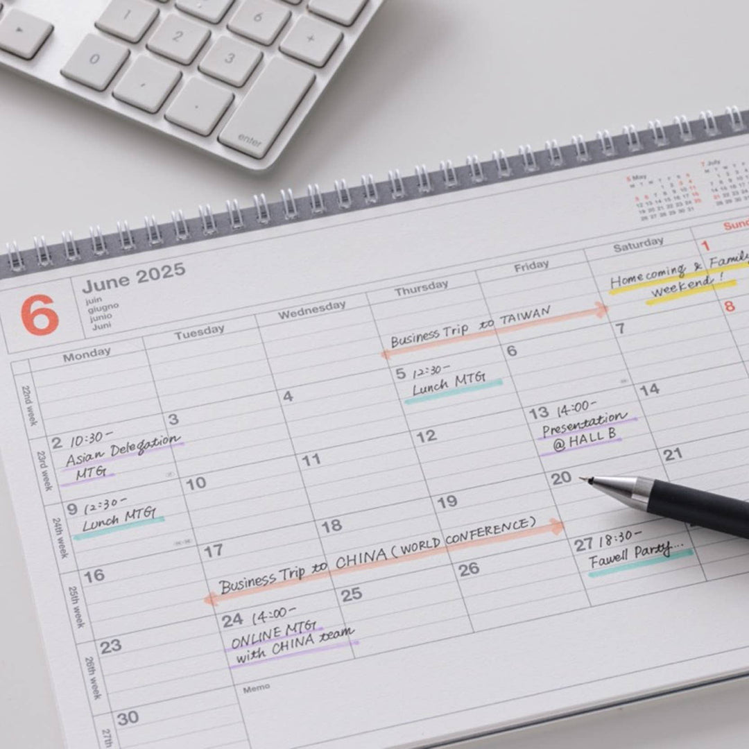 Calendar with events for June 2025 on a desk with a keyboard