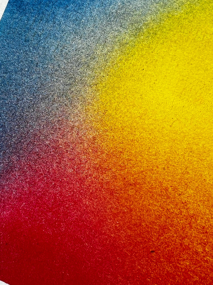 Gradient of blue, gray, yellow, and red on a textured surface