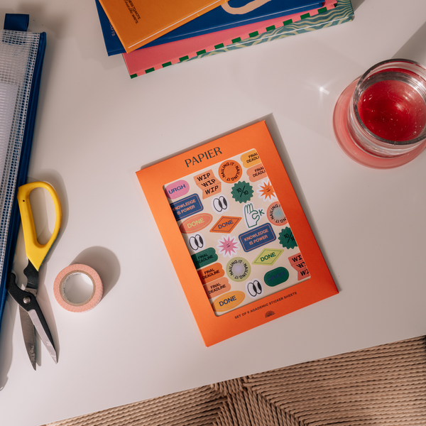 PAPIER sticker book on a white surface with scissors and tape