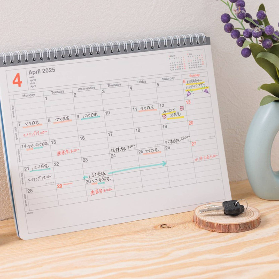 Calendar on a wooden surface with a vase of flowers in the background