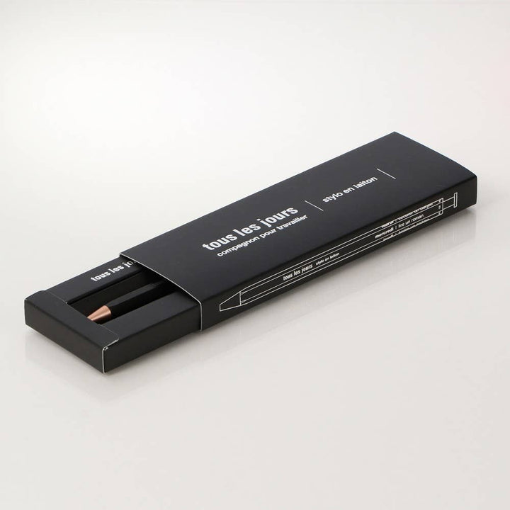 black pen in a black box with "tous les jours" written on the box.
