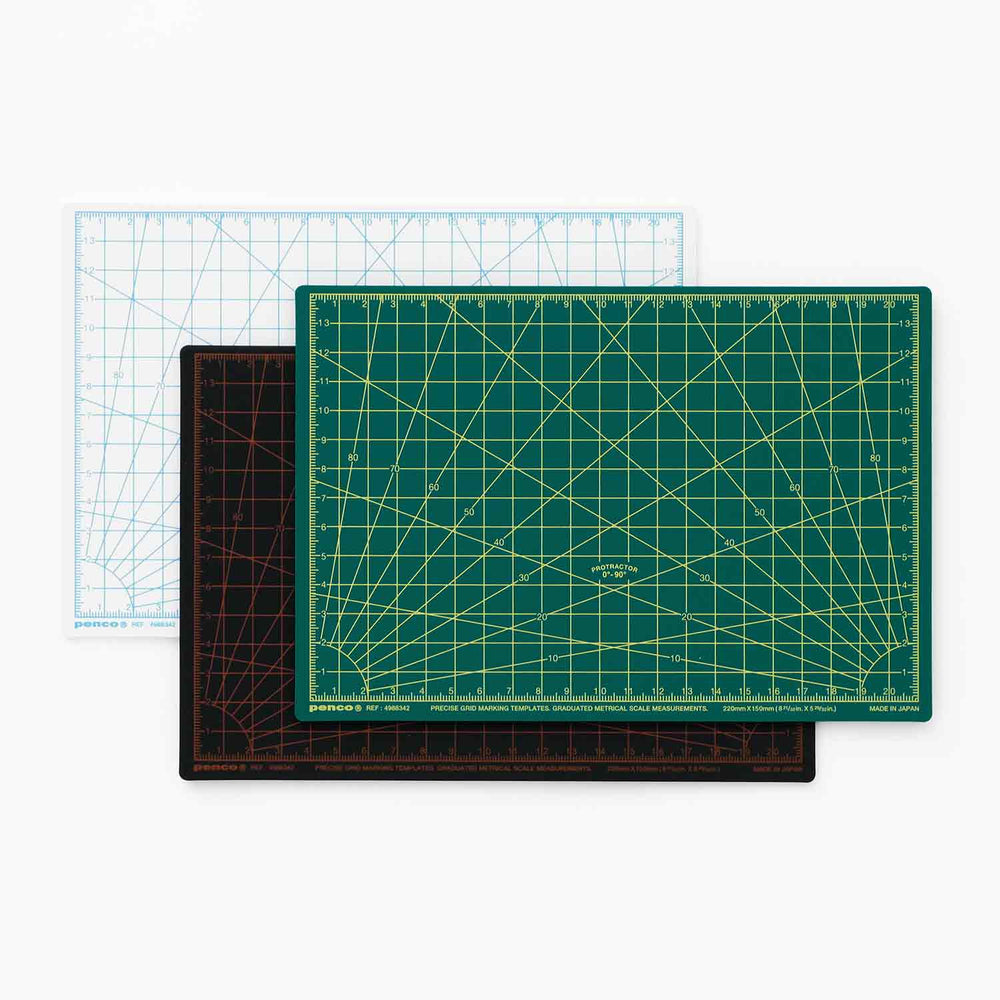 Three cutting mats with different grid patterns on a white background