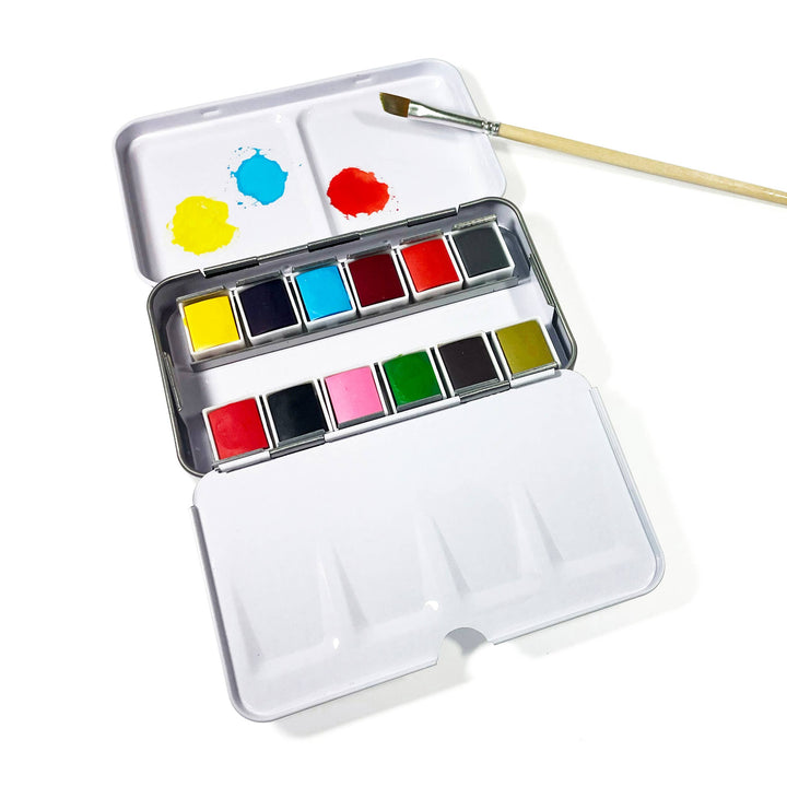 Watercolor paint set with a brush on a white background