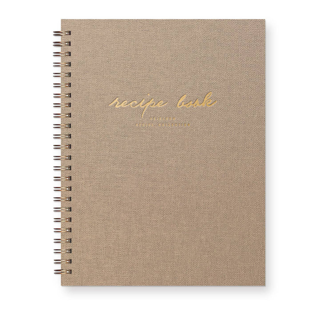 Beige recipe book with gold text on a white background
