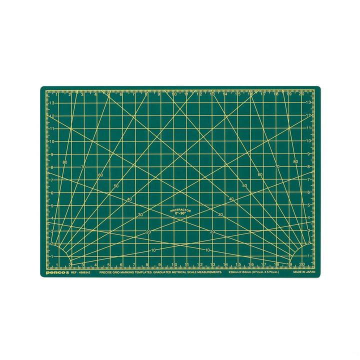 Green cutting mat with grid lines and measurements on a white background