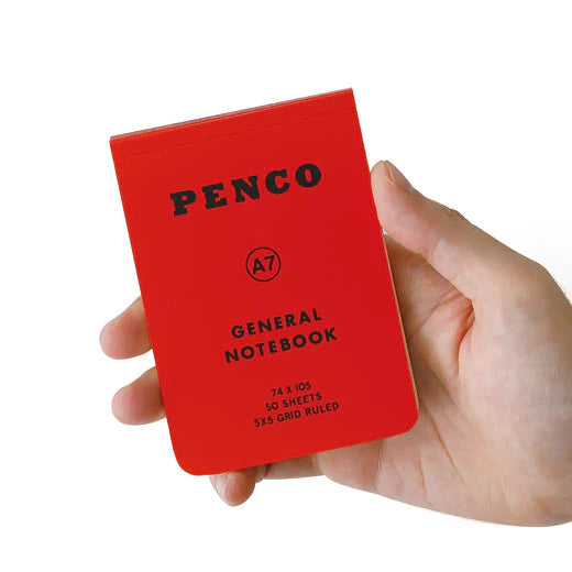 Hand holding a red Penco notebook against a white background